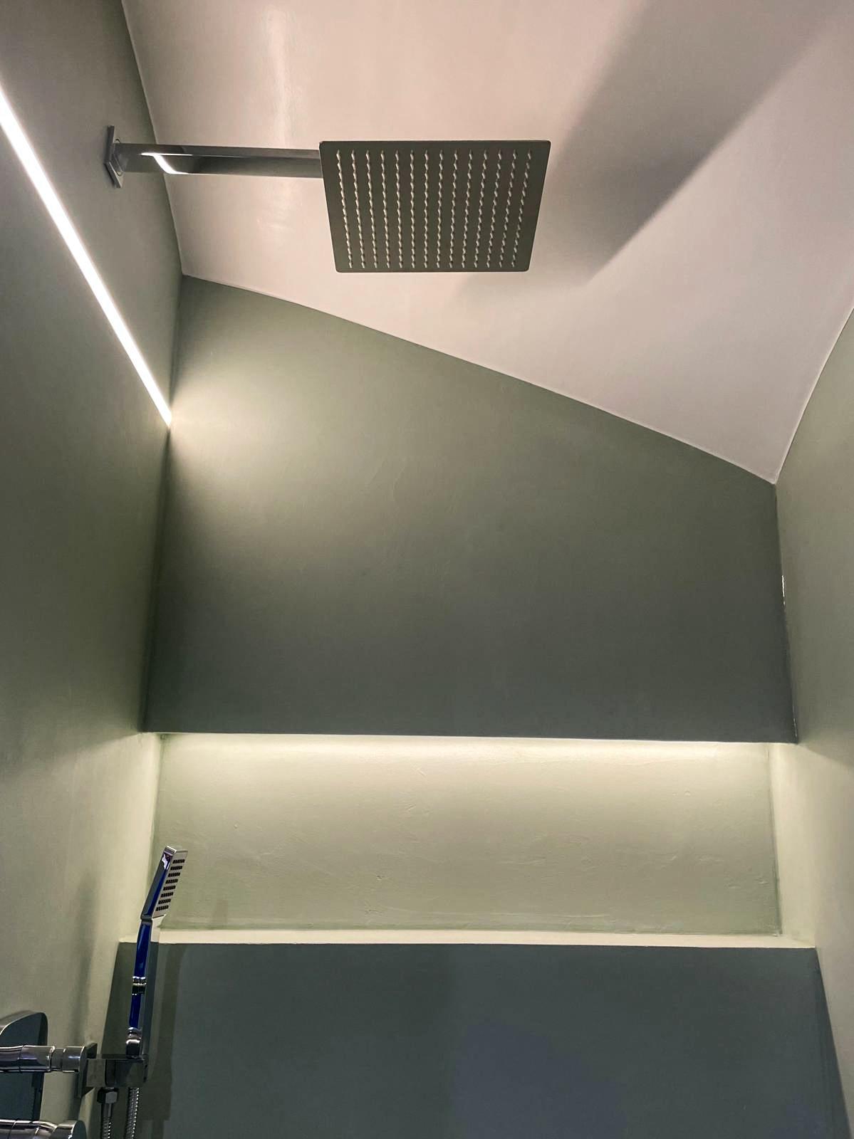 Fugenlose Duschwand in Grüntönen mit LED-Lichtband